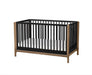 Little Seeds Laurel Island convertible crib with black slats and natural wood frame on white background.
