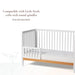 Little Seeds spindle guardrail shown attached to a white crib with round spindles on a white background.