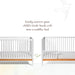 Little Seeds Spindle Guardrail shown converting a white crib into a toddler bed with wooden base.