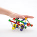 Manhattan Toy Skwish wooden rattle teether in a hand, colorful rods and beads on white background.