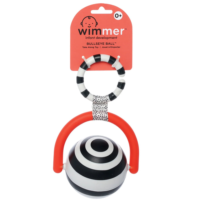 Wimmer Bullseye Ball infant sensory toy with black and white stripes and bright red handle, hanging on display.