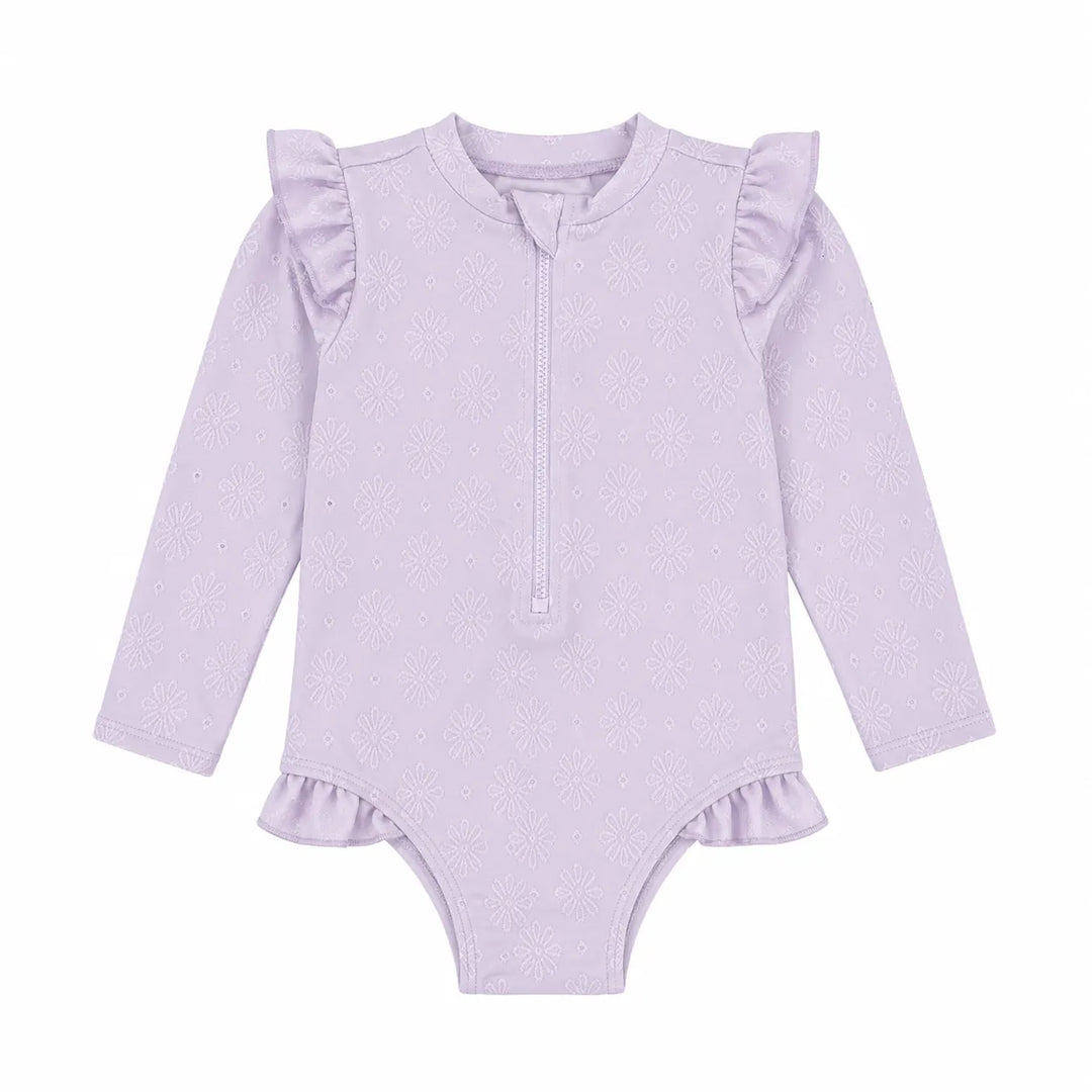 Baby rashguard swimsuit in light purple with long sleeves, floral pattern, and ruffle details, shown flat.
