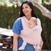 Moby Easy Wrap Baby Carrier in rose holding an infant, worn by a woman outdoors.