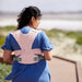 Moby Easy Wrap Baby Carrier in rose shown on a woman outdoors, holding a baby close to her chest.