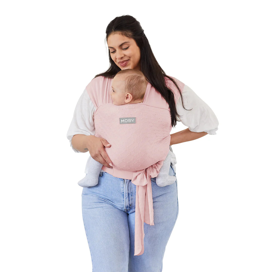 Moby Easy Wrap Baby Carrier in rose worn by a woman carrying a baby on her front.