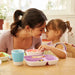Munchkin Splash Divided Baby Plate Set with food, shown on a table with a toddler and adult.