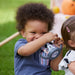 Nuk Disney Mickey sippy cup held by a toddler sitting outdoors on grass.