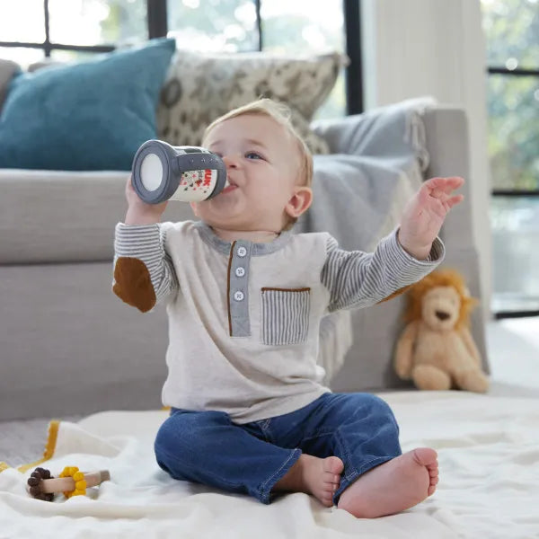 NUK Disney Mickey sippy cup for toddlers shown with a baby drinking on a living room floor.