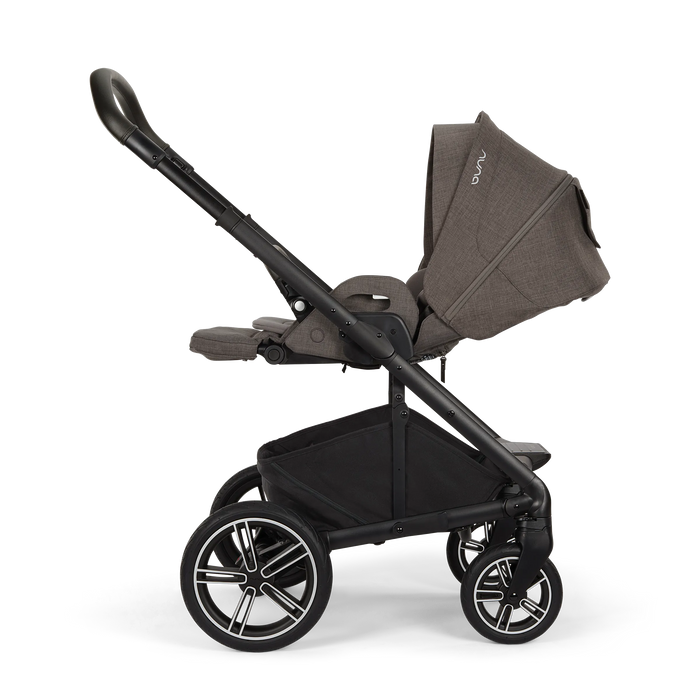 Nuna Mixx Next baby stroller in side view with canopy extended and storage basket visible.