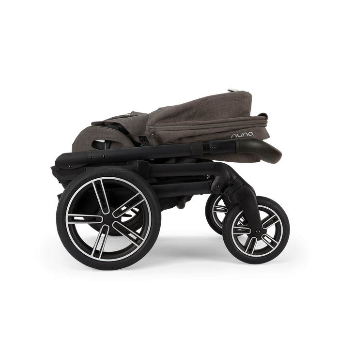 Nuna Mixx Next baby stroller shown folded flat with black frame and large wheels.