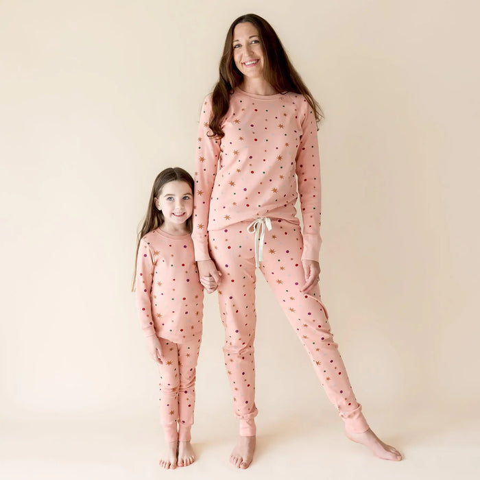 Parade Organics organic cotton jammies worn by a woman and child standing barefoot together.