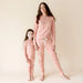 Parade Organics organic cotton jammies worn by a woman and child standing barefoot together.
