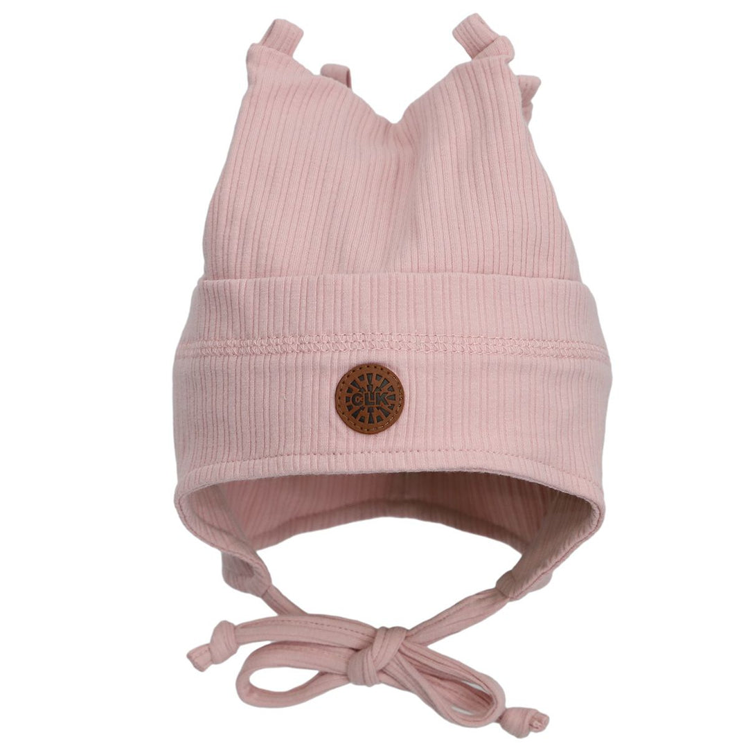 Pink ribbed baby hat with ear flaps, chin ties, and decorative top knots