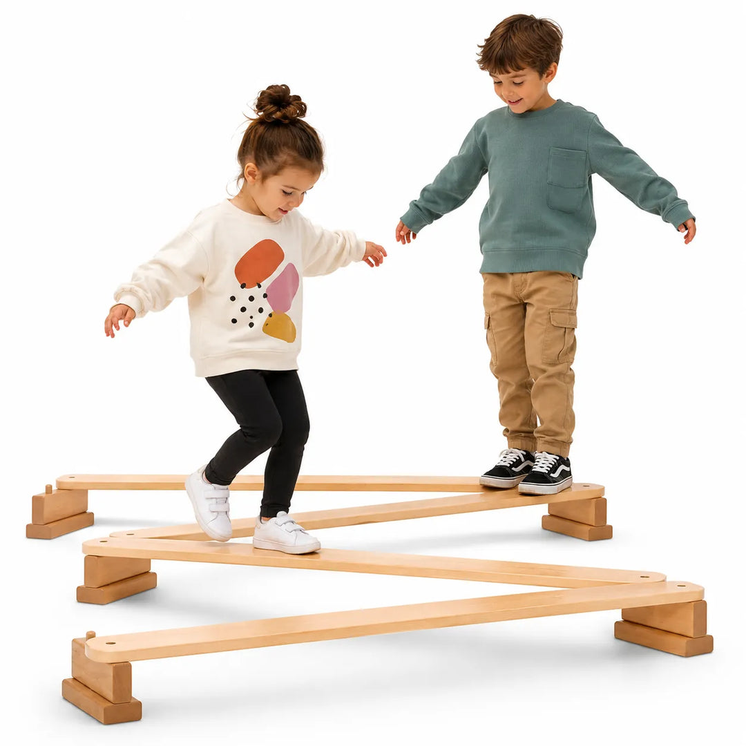 Two children playing on a maple wooden balance beam against a white background