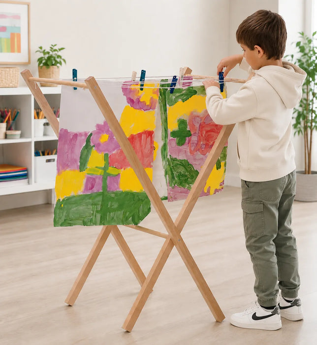 Solid Maple Wood Arts and Crafts Drying Rack for Kids with a boy hanging his paintings in the living room