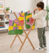 Solid Maple Wood Arts and Crafts Drying Rack for Kids with a boy hanging his paintings in the living room