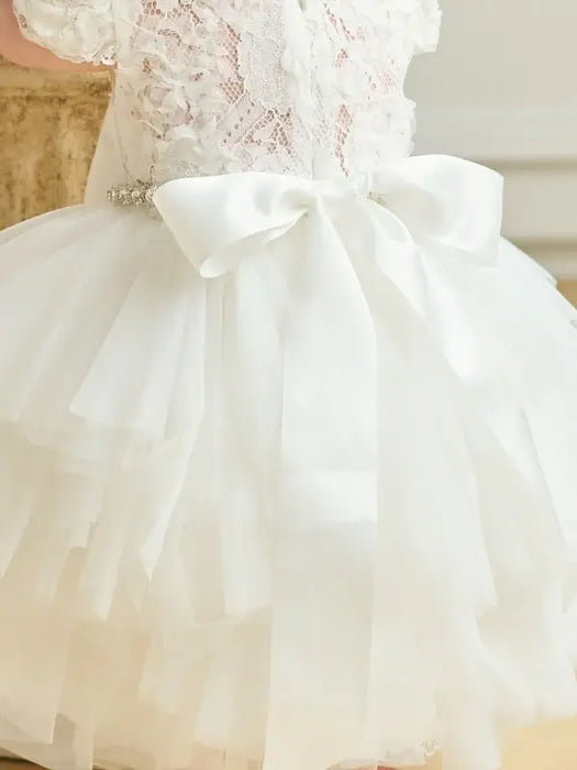 Warm Wendy Off-White Lace Baptism Dress shown from the back with tulle skirt and satin bow.