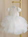Warm Wendy off-white lace baptism dress with short sleeves and tulle skirt hanging on a gold rack