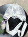 Teter Warm 3D floral lace baby bonnet with satin ties displayed on a black surface.