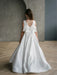Teter Warm Tara satin bow communion dress shown on a girl standing indoors facing away