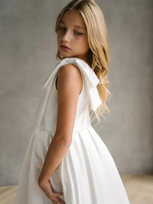 Addison Satin Bow Shoulder Communion Dress shown on a young girl in a studio setting.