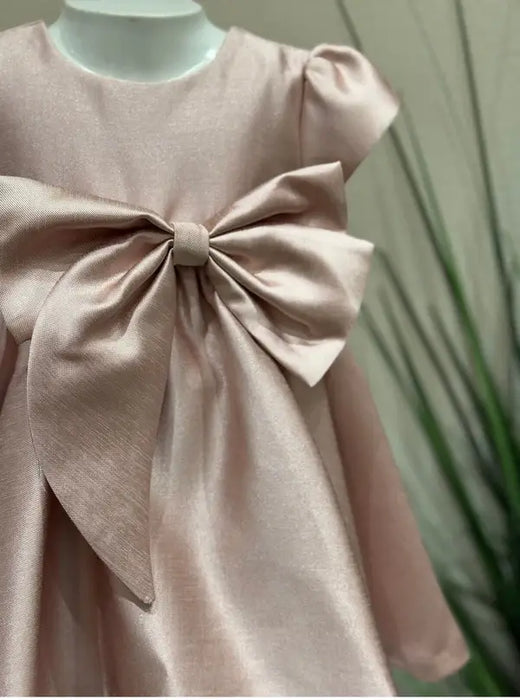 Teter Warm Ailani pink metallic party dress with large front bow displayed on mannequin
