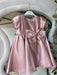 Teter Warm Ailani pink metallic party dress with short sleeves and large bow displayed on a hanger