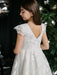 Teter Warm Angelica Lace Communion Dress shown on a girl standing near a decorated tree.