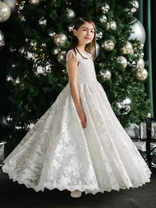 Teter Warm Angelica Lace Communion Dress worn by a girl standing in front of a decorated Christmas tree.