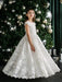 Angelica Lace Communion Dress displayed on a girl standing in front of a decorated Christmas tree.