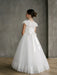 Teter Warm Ariana Lace Communion Dress shown on a girl standing indoors with a lace back and bow.