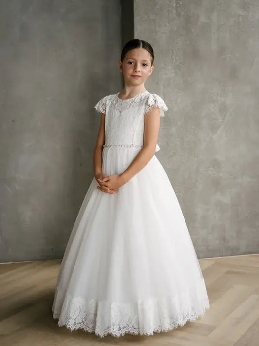 Teter Warm Ariana Lace Communion Dress shown on a girl standing indoors against a gray background.