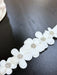 Teter Warm baby girl floral headband with rhinestones displayed on a dark wooden surface.
