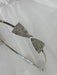 Teter Warm Beatrix Silver Headband with a sparkly bow detail displayed on white fabric.
