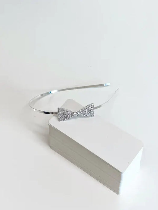 Teter Warm Beatrix Silver Headband with crystal bow detail displayed on white box.