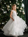 Teter Warm Billie off-white communion dress worn by a girl standing in front of a decorated Christmas tree.