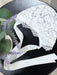 Teter Warm Bold Floral Bay Bonnet white lace baby bonnet with satin ribbons on a dark round table.