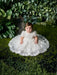 Teter Warm Carlita 3D floral lace baptism dress shown on a baby sitting on green moss.