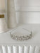 Cecilia rhinestone headpiece with pearl and crystal accents displayed on a white shelf.