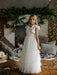 Teter Warm Celeste off-white communion dress worn by a girl standing indoors with festive decor.