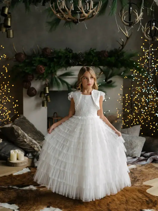 Teter Warm Celeste off-white communion dress worn by a girl standing in a decorated living room.