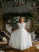 Teter Warm Celeste off-white communion dress worn by a girl standing in a decorated living room.