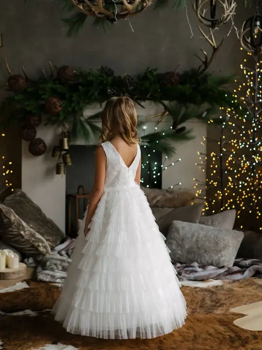 Teter Warm Celeste Off-White Communion Dress shown on a young girl standing in a decorated living room.