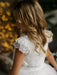 Teter Warm Celeste off-white communion dress with lace sleeves shown on a girl in soft indoor lighting.