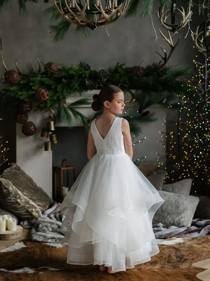 Teter Warm Cora off white communion dress shown on a girl standing in a decorated living room