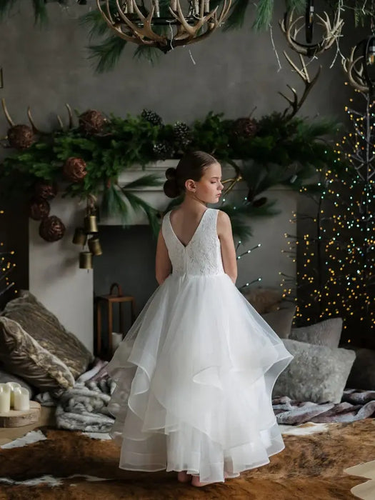 Teter Warm Cora off white communion dress shown on a girl standing in a decorated living room