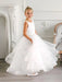 Teter Warm Cora off-white communion dress worn by a young girl standing in an elegant room.