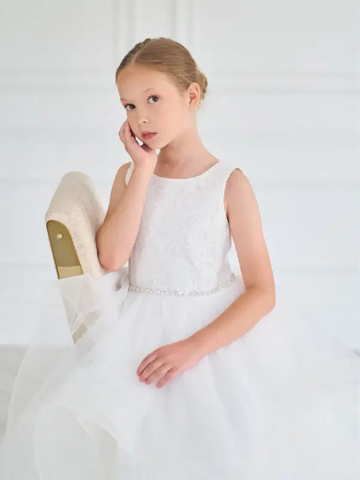 Teter Warm Cora Off White Communion Dress shown on a young girl sitting on a chair in a bright room.