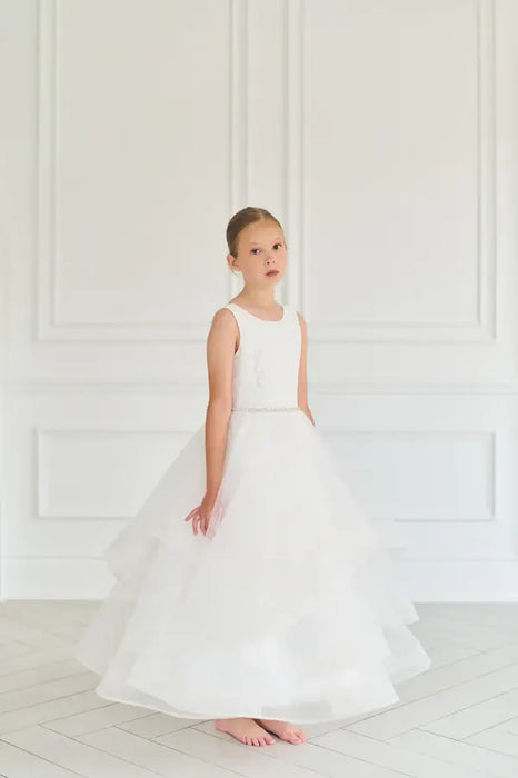 Teter Warm Cora off-white communion dress worn by a young girl standing in a bright room.