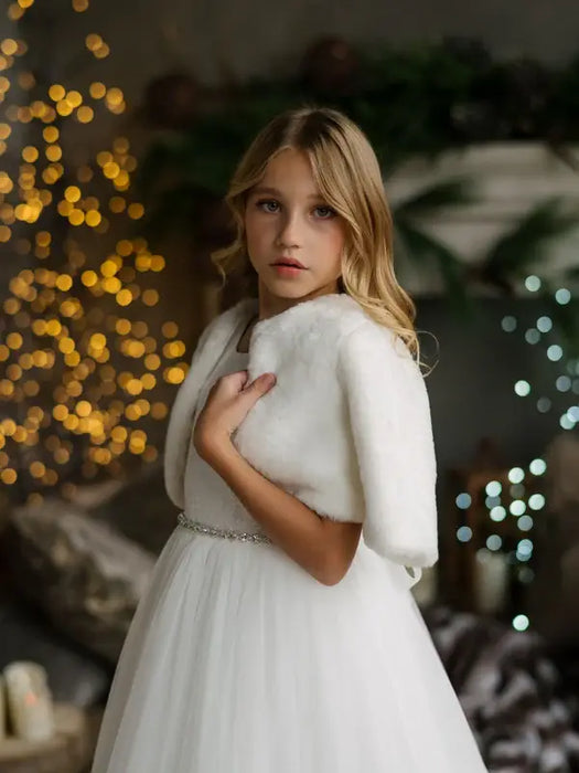 Teter Warm Dakota faux fur jacket worn by a young girl over a white dress in a festive setting.